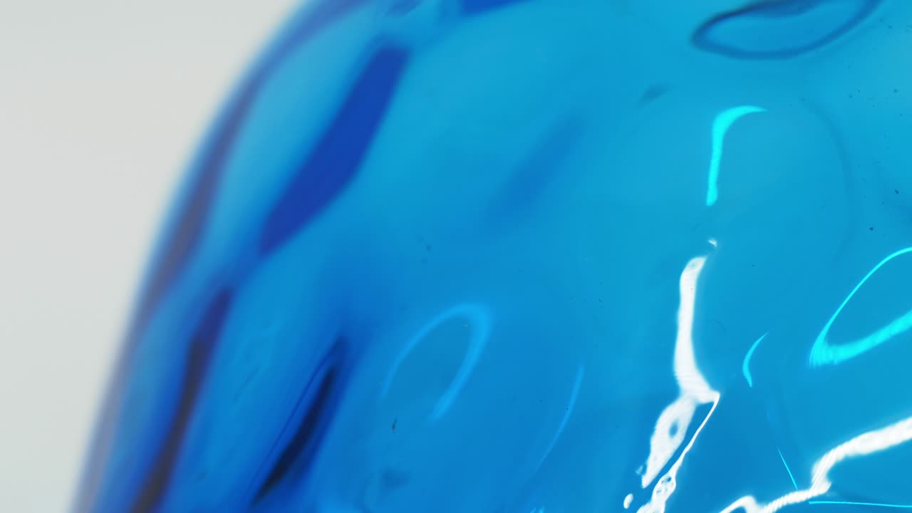 색 배경 루프에 추상적인 회전하는 파란색 유리품