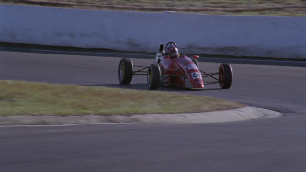 두 대의 경주용 자동차가 트랙의 빠른 회전에서 빠져나옵니다.