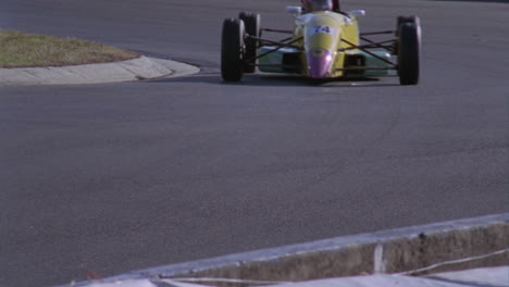 two race cars pull out of a fast turn on a track