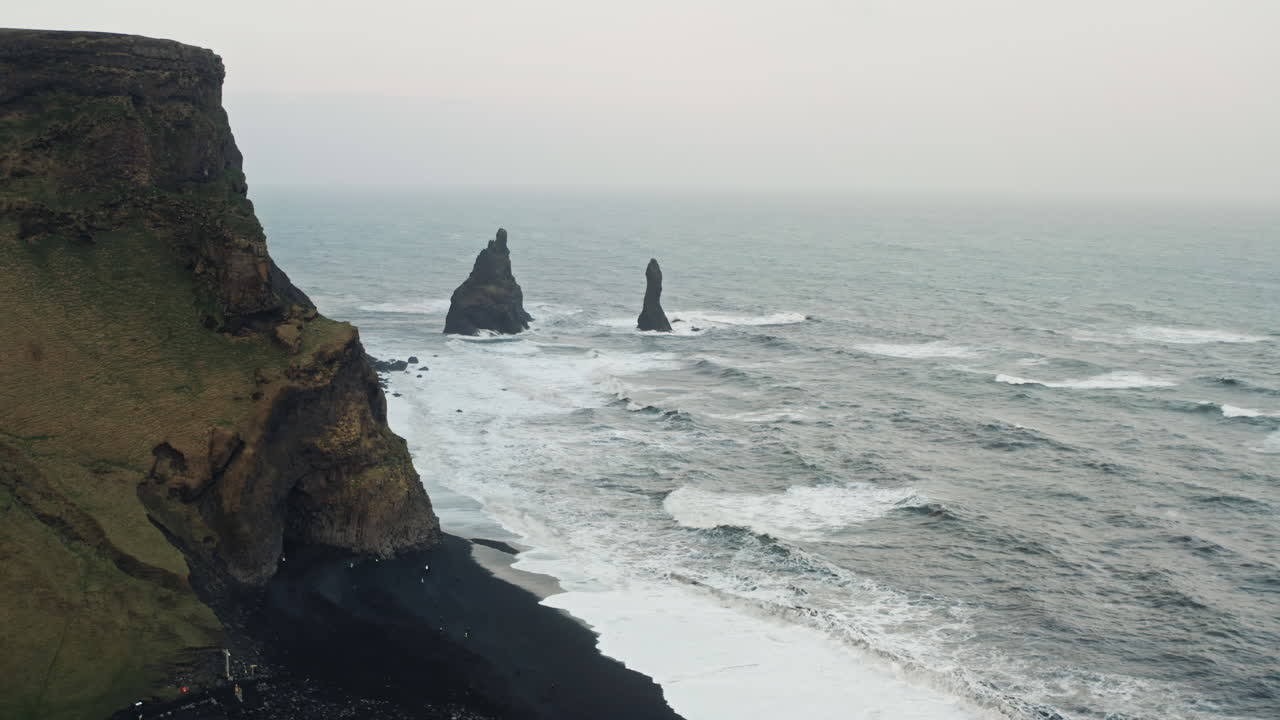 tomada aérea cinematográfica de la playa de arena negra de reynisfjara, vik - islandia