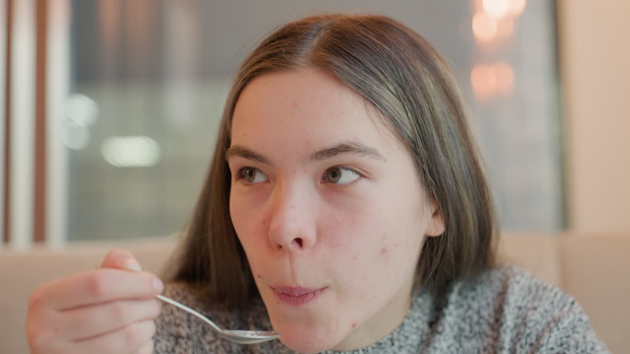 Close-up of freelancer sipping hot drink with a surprised expression, blinking eyes in reaction to something delicious, seated in a cozy cafe, enjoying her refreshing moment of relaxation