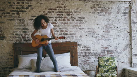woman playing guitar on bed