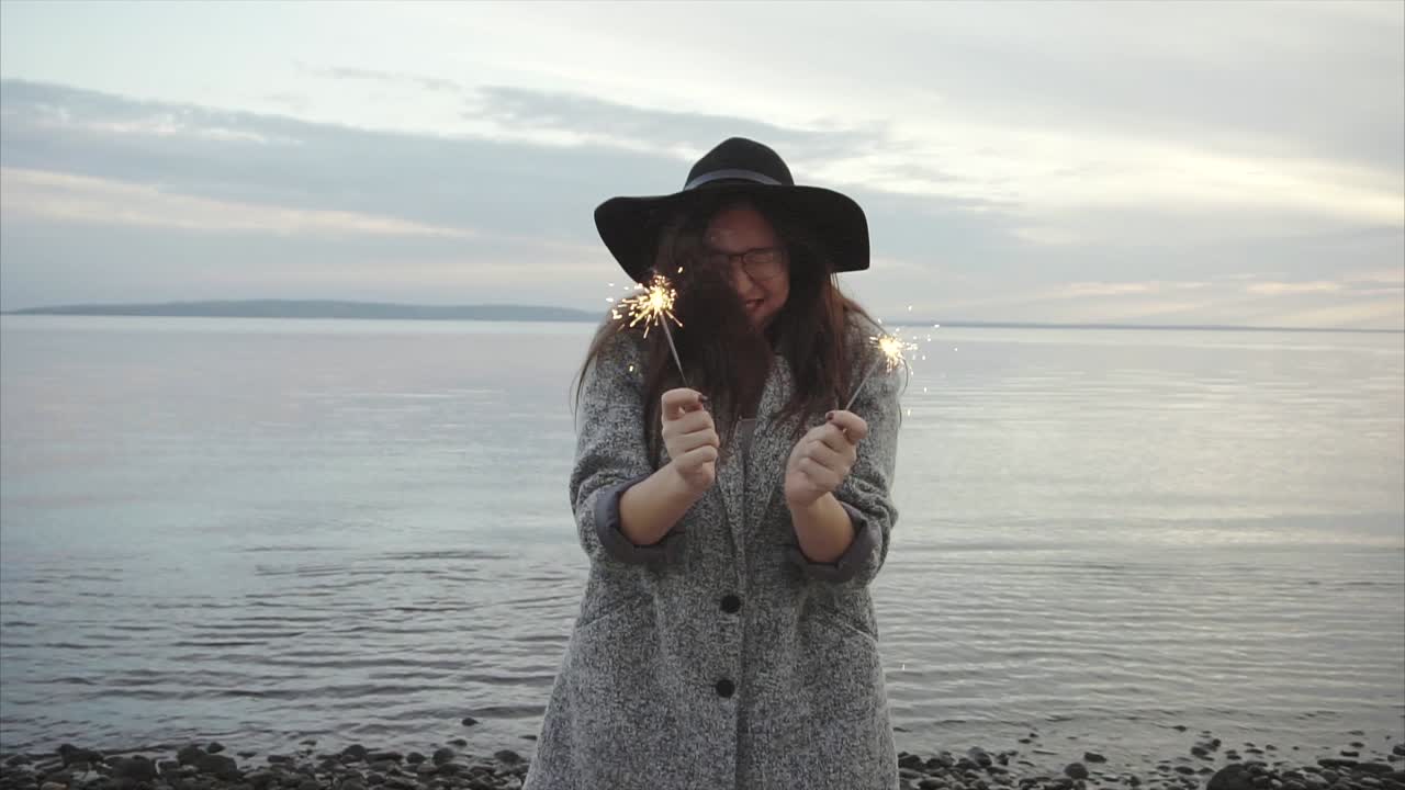 Woman Celebrating with Sparkler on the Beach
