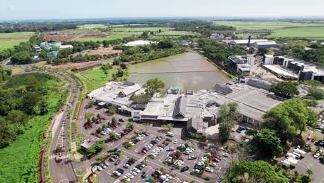 mahogany mall in mauritius with lush greenery and parking lot, sunny day, drone shot, aerial view