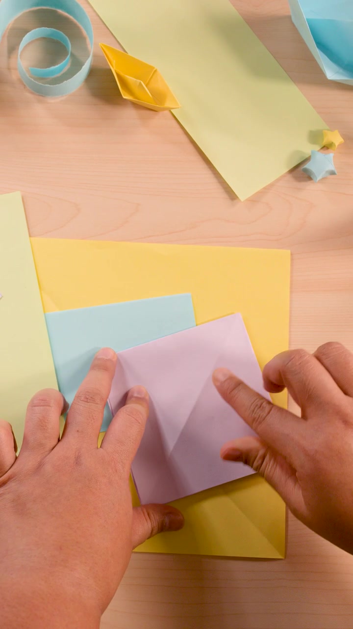 Persona che piega carta colorata per un progetto di origami