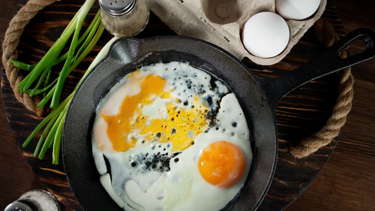 The frying pan with fried eggs rotates slowly.