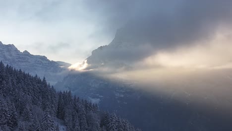 golden sunrise through snowy clouds over klöntalersee in glarus, switzerland, serene aerial view of alpine mountains, frosted trees and tranquil winter landscapes.