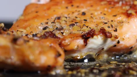 espolvorear condimentos y especias para cocinar filetes de salmón en aceite - cerrar