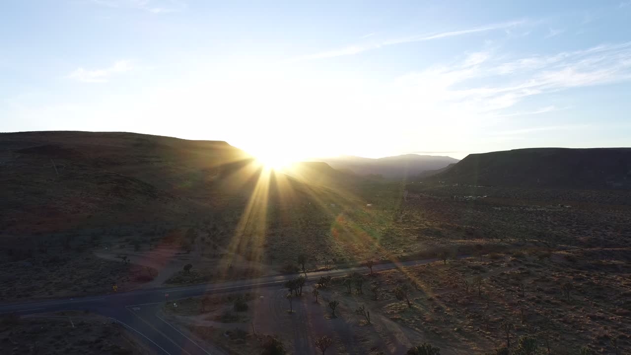 un camión conduciendo en una carretera de campo en yucca valley en california al atardecer en una encrucijada