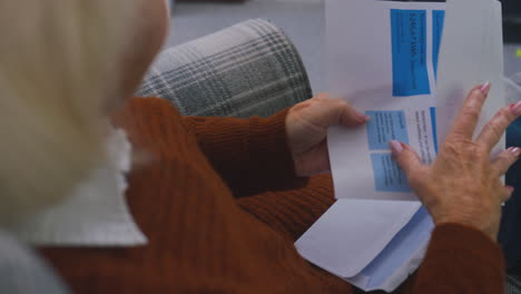 Close Up Of Senior Woman At Home Looking At USA Energy Bill During Cost Of Living Energy Crisis