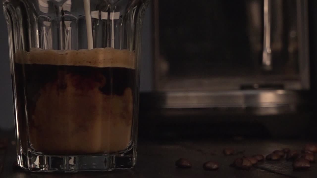 Coffee glas filled with milk in slow motion