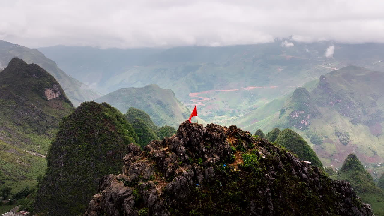 Vietnam Flag on top of mountain. Aerial backward