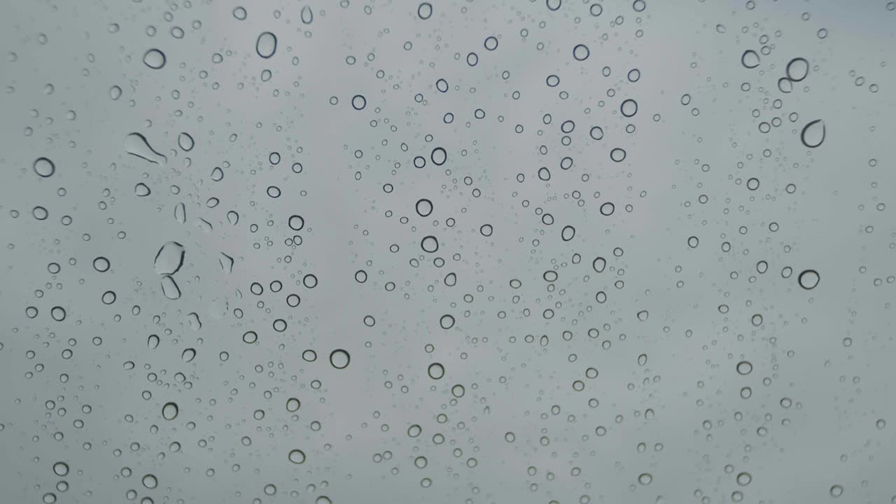 gotas de lluvia en el parabrisas del coche a cámara lenta