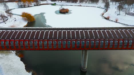 hurka luziny metro bridge crossing over frozen pond in snowy park, prague
