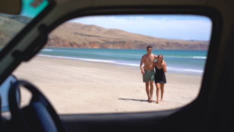 Una-Pareja-Caminando-Y-Riendo-En-La-Playa