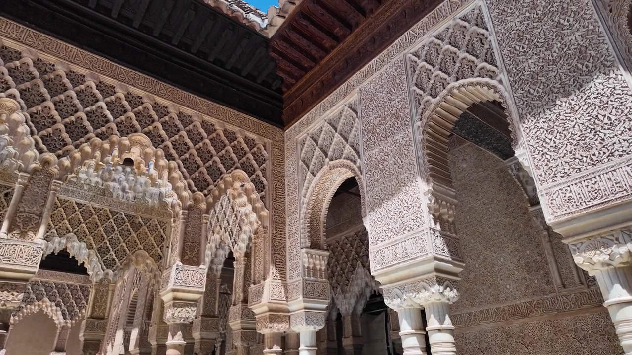 Filmato al rallentatore di archi ornati, decorazioni in stucco intagliato e architettura islamica all'interno dei Palazzi Nasridi dell'Alhambra a Granada, Spagna.