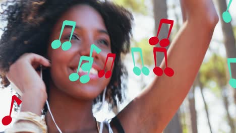 animation of notes icons over smiling african american woman with earphones dancing