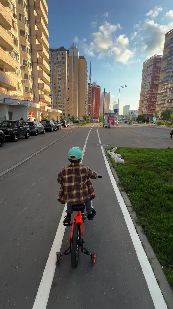 A child rides a bicycle on a city street