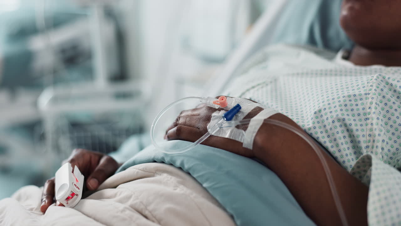 Patient hand, bed and drip in closeup