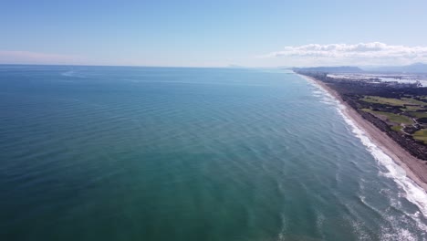 4k aerial shot of mediterranean coastline with waves, pine forest in albufera natural park, valencia, spain