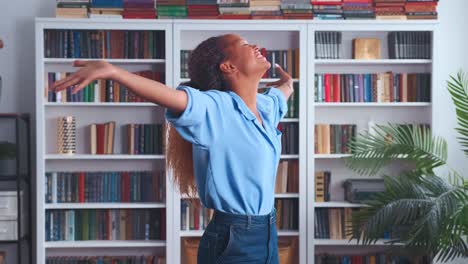 joven feliz mujer afroamericana estudiante lanza los brazos a un lado y girar