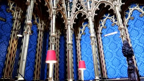 panning shot of blue velvet walls with red lamps in westminster abbey, london