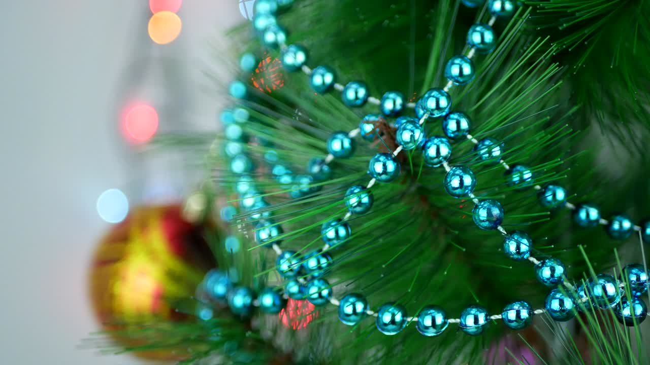 guirnalda decorativa de turquesa en el árbol de navidad con bolos borrosos