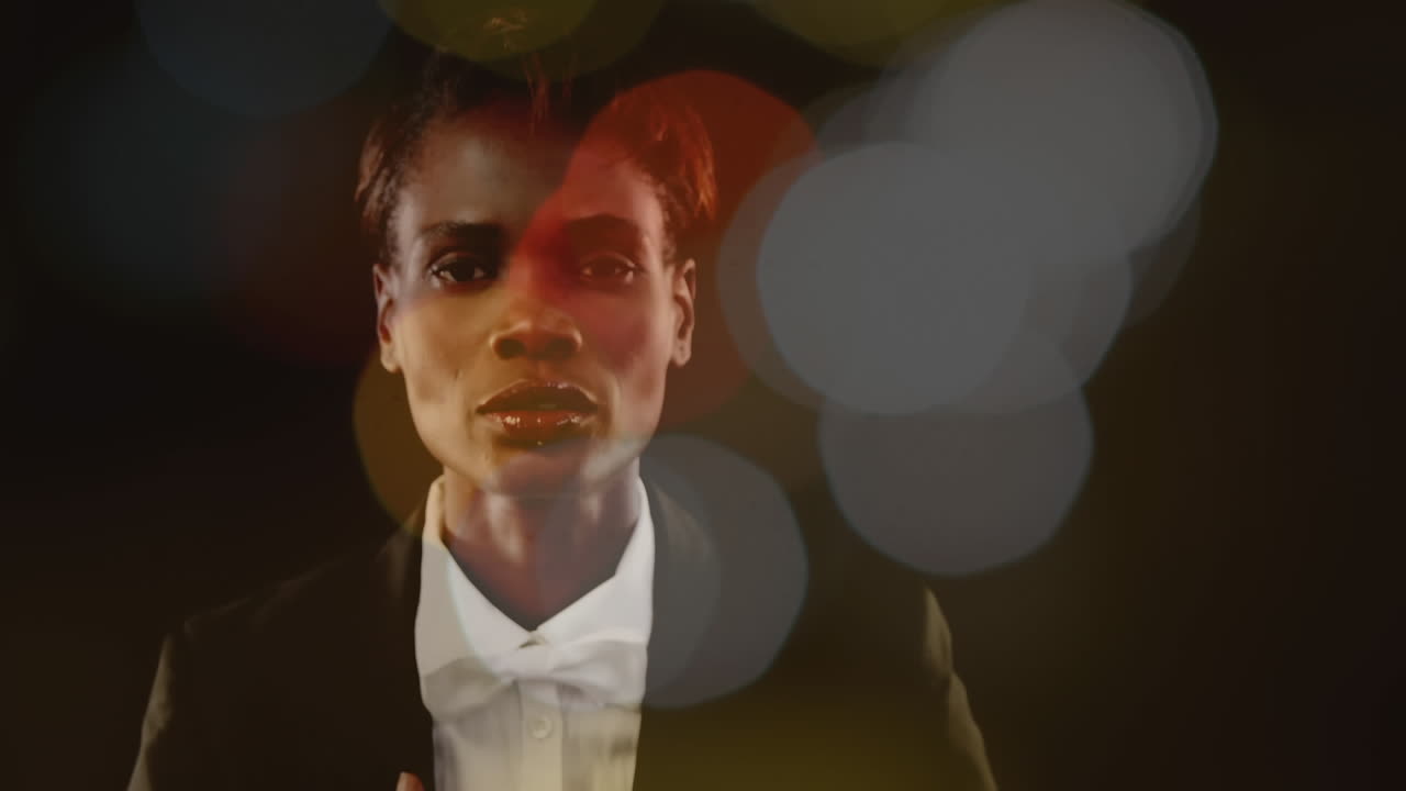 Businesswoman looking at camera surrounded by bokeh effect