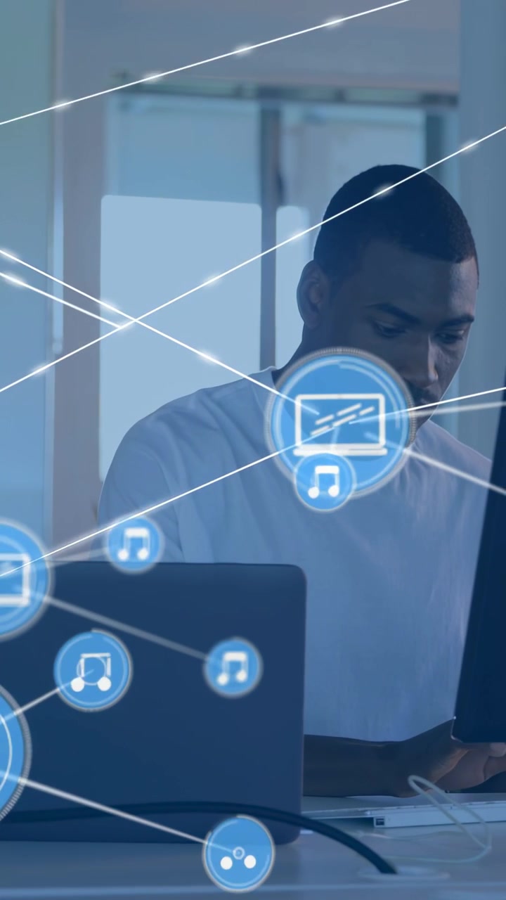 Vertical video: Laptop icon popping as man typing at desk, HUD spreading, mapping tech device links
