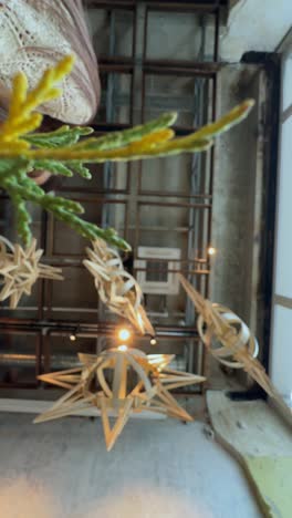 mujer decorando con estrellas y plantas de navidad