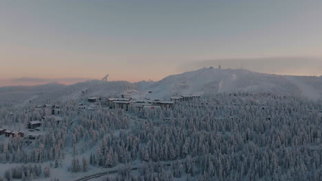 aerial view rising toward the ruka town, polar night, winter evening in finland