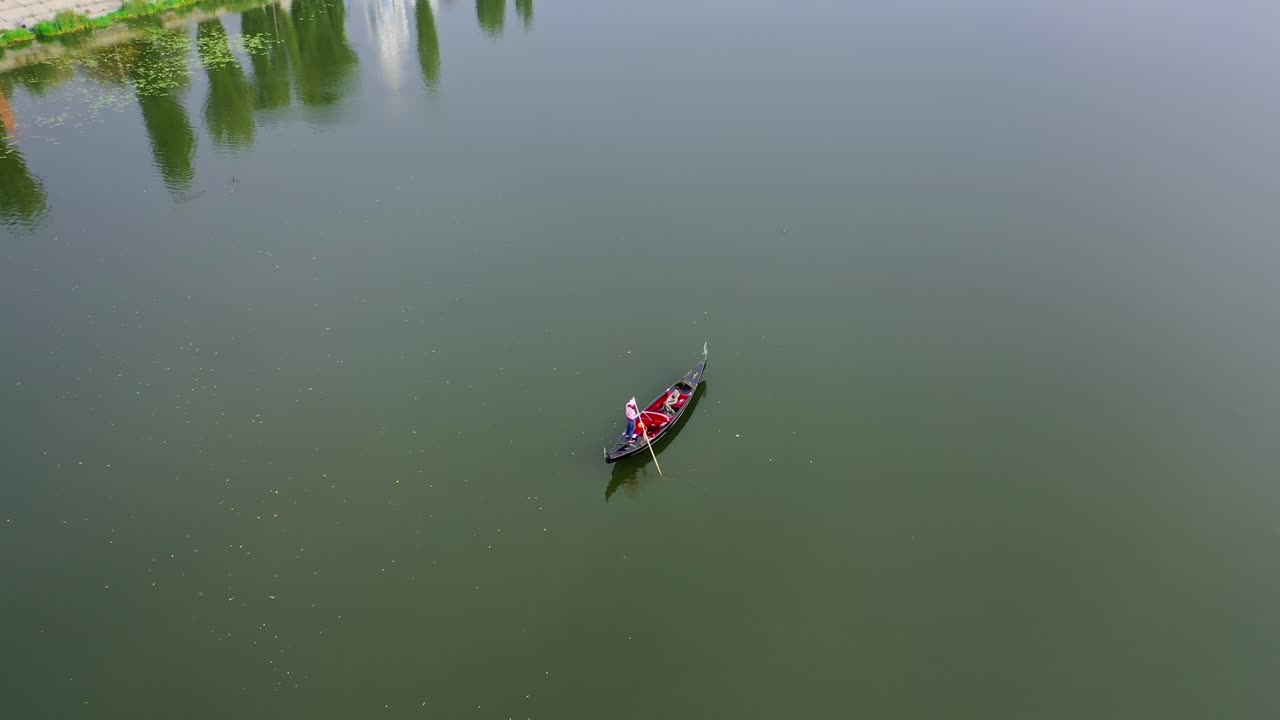 Boat floating on water. View from above on gondola sailing along the wide river. Romantic atmosphere. Aerial view.