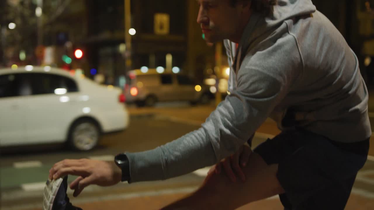 Uomo caucasico che fa sport per strada di sera