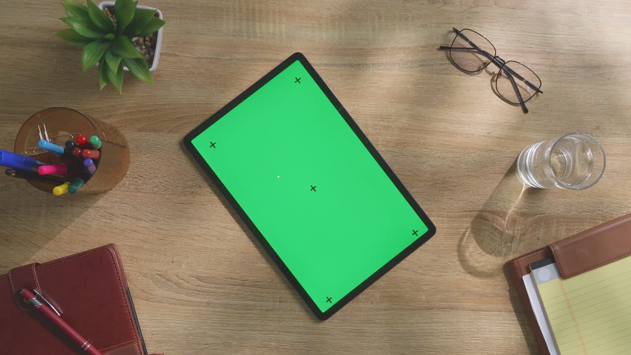 escritorio de oficina con tableta y pantalla verde