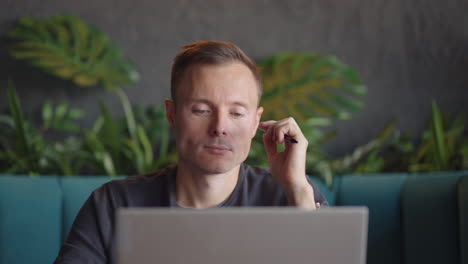 Thoughtful serious young man student writer sit at home office desk with laptop thinking of inspiration search problem solution ideas lost in thoughts concept dreaming looking away