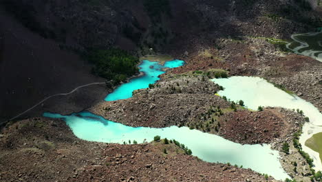 Tiro-De-Drone-De-Agua-De-Color-Turquesa-En-Las-Montañas-En-El-Valle-De-Naltar-En-Pakistán,-Lentamente-Descendiendo-Y-Girando-Tiro-Aéreo