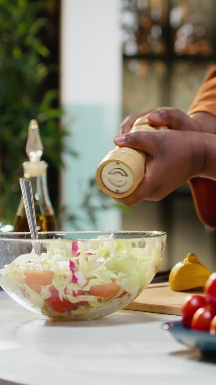 Video verticale, donna di colore, succo di limone spremuto, olio d'oliva versato, condimento per insalata in ciotola