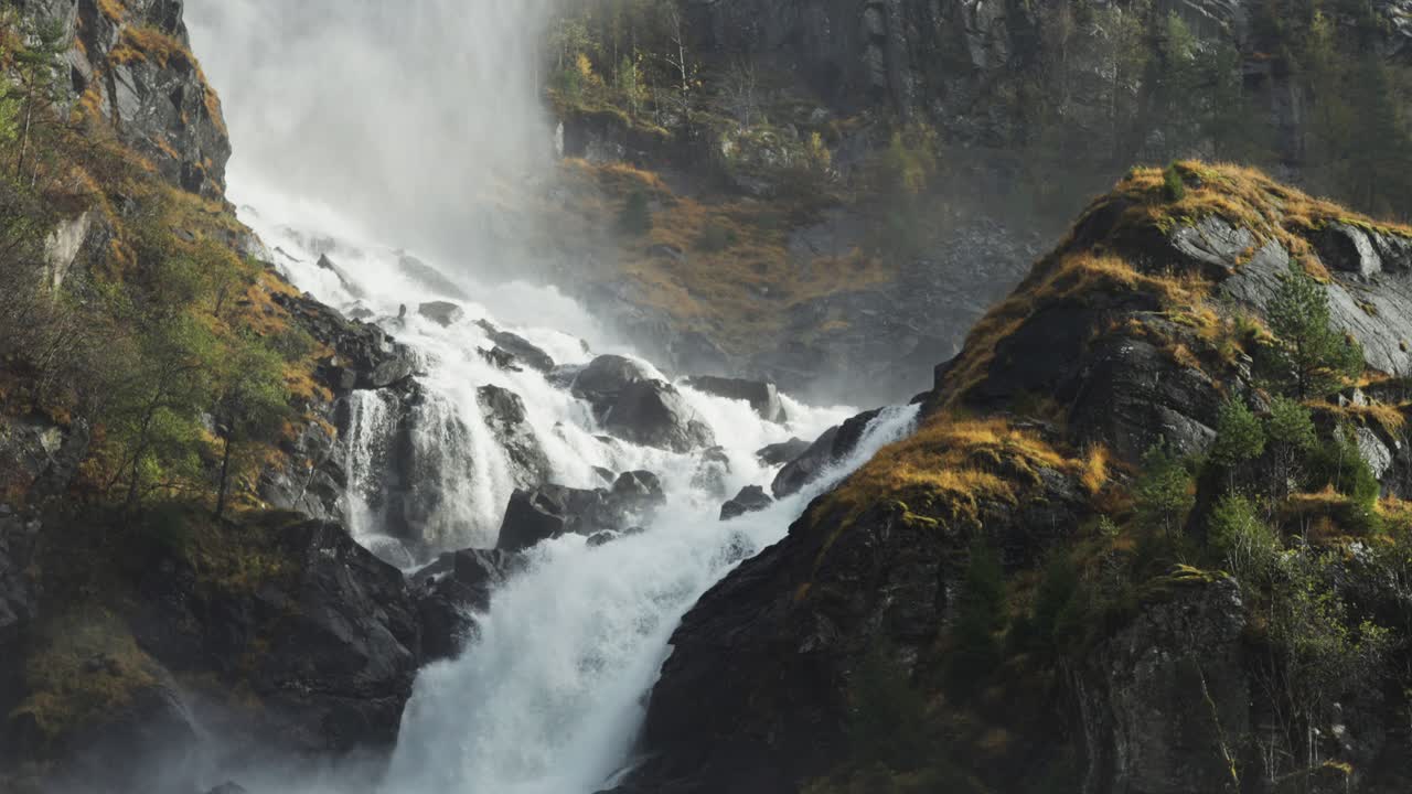 un poderoso torrente de agua se precipita sobre las rocas cubiertas de musgo