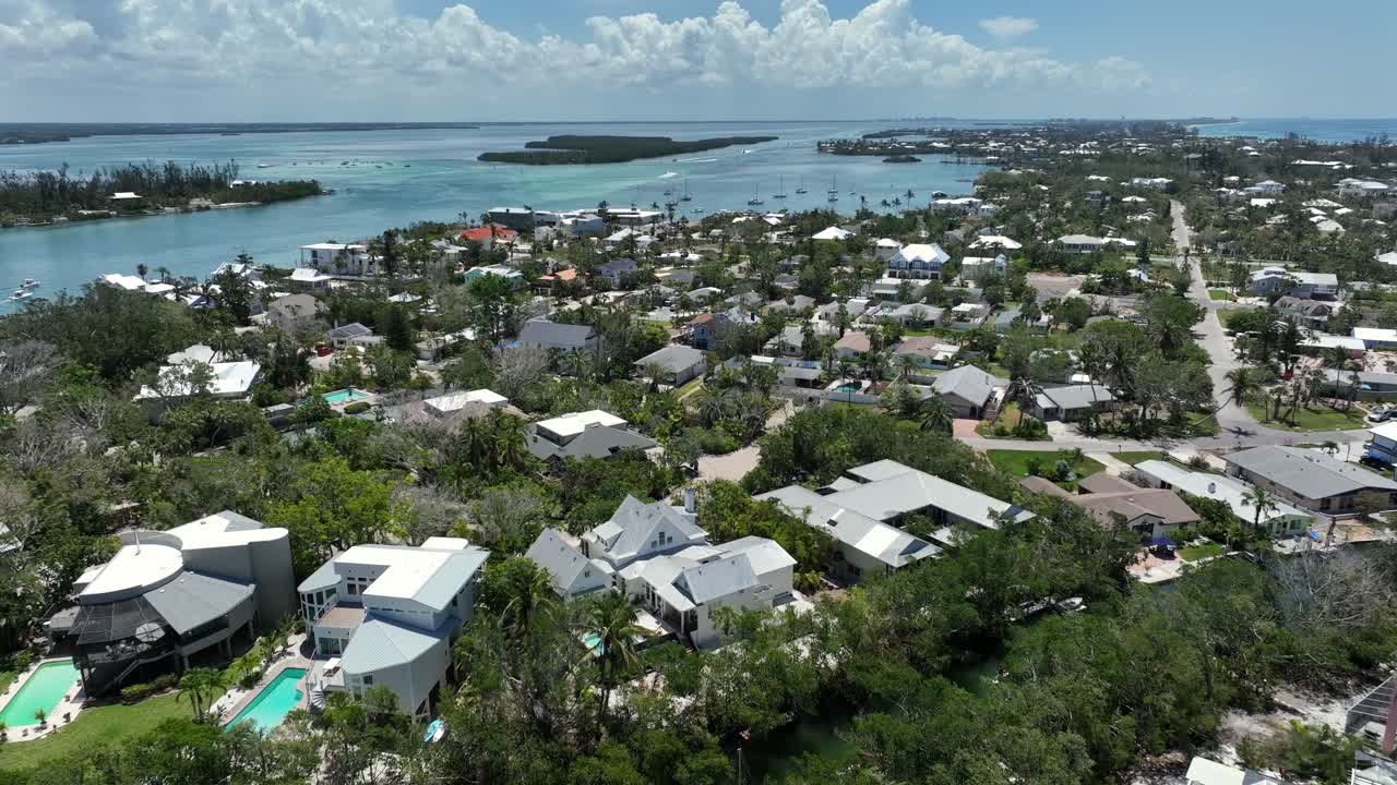 Aerial flight over luxury houses and homes of coquina beach in Florida. Water river and bay in background. Luxury city in Florida, United States. Sunny day with blue sky.