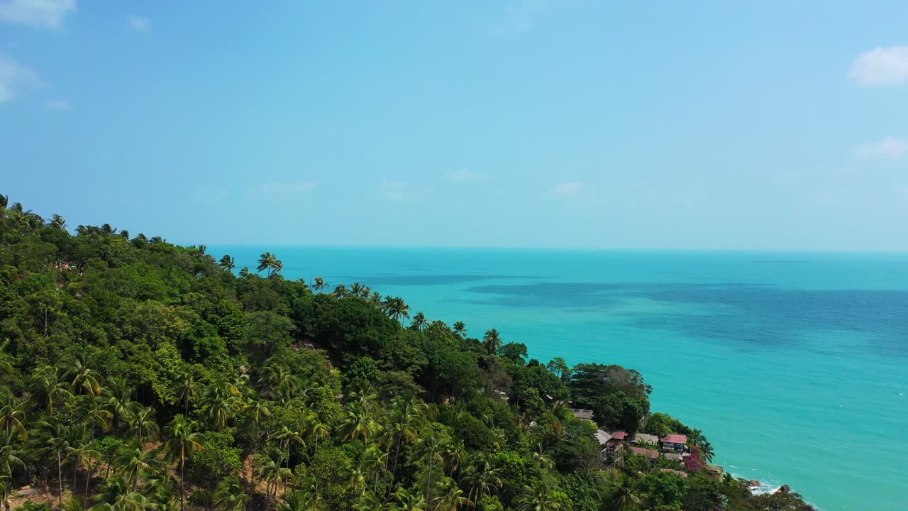 Peaceful landscape of tropical island with green trees rainforest on slopes of hills over calm turquoise sea water in Thailand