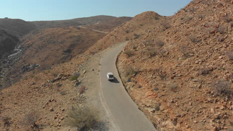 aerial follow car driving up narrow road up hill