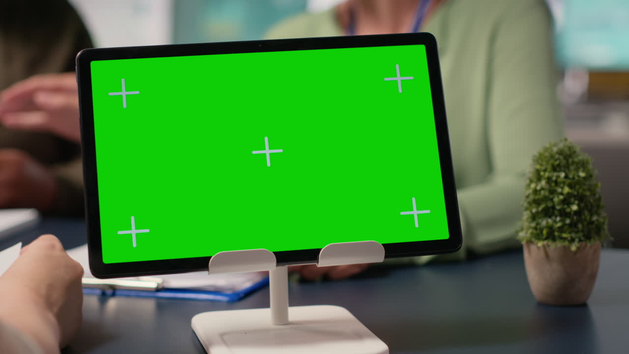 Corporate women gather with a chroma key display in modern work environment