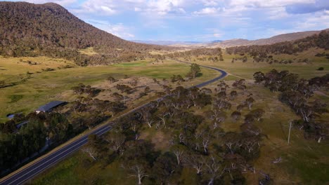 drone view of country farm house and road with overcast sky in crackenback, new south wales, australia