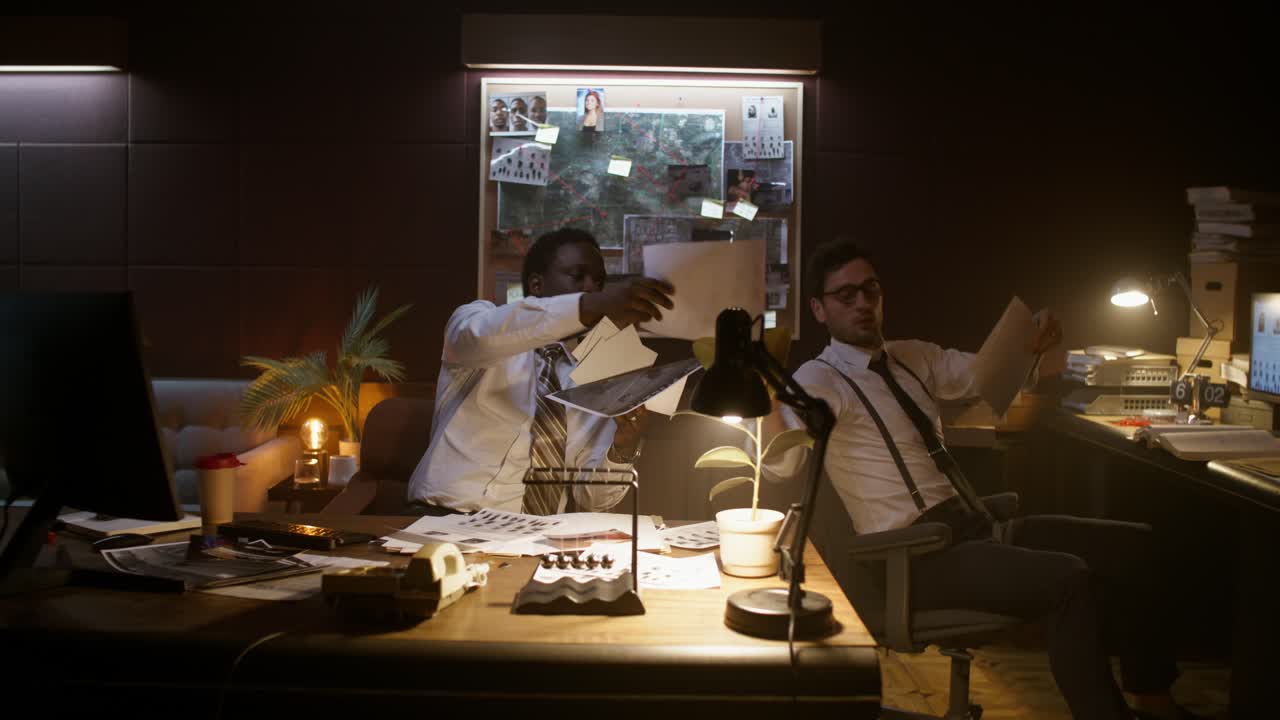 Detectives Reviewing Evidence in a Crime Scene Office at Night