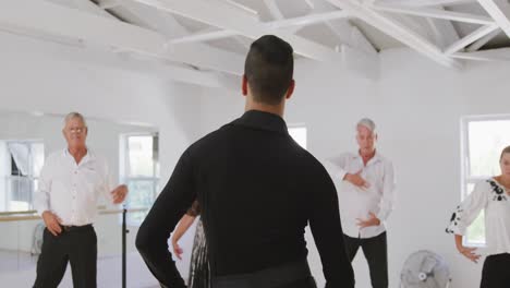 mixed race male dance teacher taking a ballroom dancing class at a dance studio