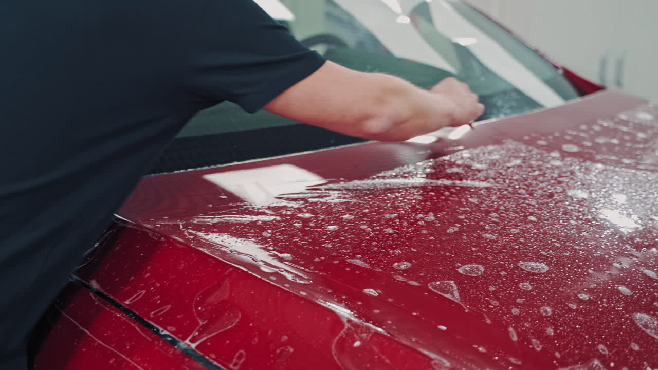 Pasting machine specially film. Car wrapping specialists straightening film to remove air bubbles