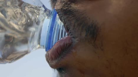 man drinking water from a bottle