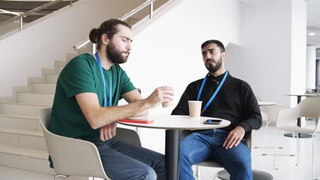 dos hombres teniendo una reunión de negocios o conversación en un entorno de oficina