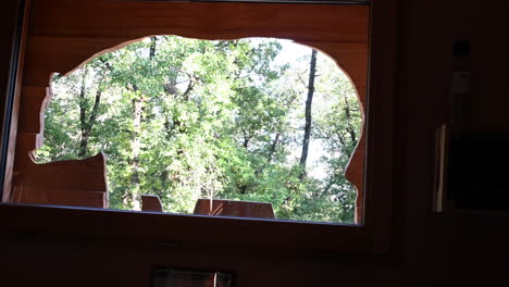 silhouette of a sculpted bear in a wooden hut, view of the trees of a forest in the background
