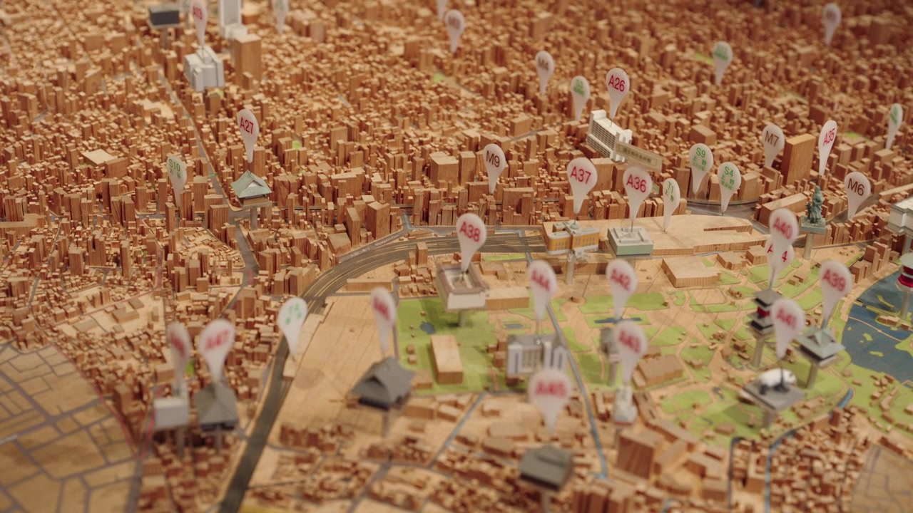 Detailed miniature scale model of Tokyo city with labeled location markers buildings and rail tracks Japan